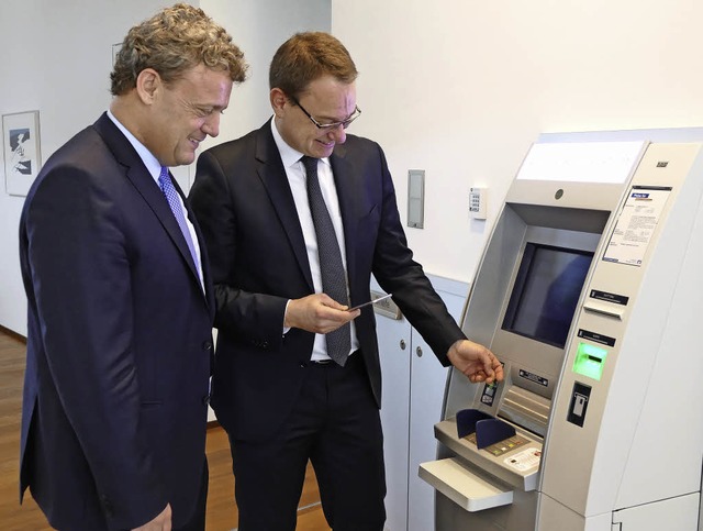 Volksbank-Vorstandssprecher Jrg Dehle... am Bankautomaten Geld abheben lsst.   | Foto: Barbara Schmidt