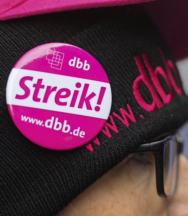 Eine Frau mit einen Button des DBB- Beamtenbunds in Stuttgart   | Foto: dpa