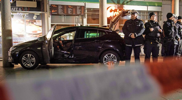 Polizeibeamte schirmen das Tatfahrzeug in der Heilberger Innenstadt ab.   | Foto: dpa