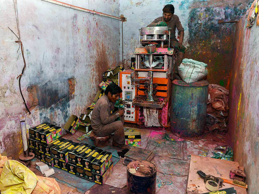 Indische Arbeiter packen umweltfreundliches Farbpulver fr das Holi-Festival ab.