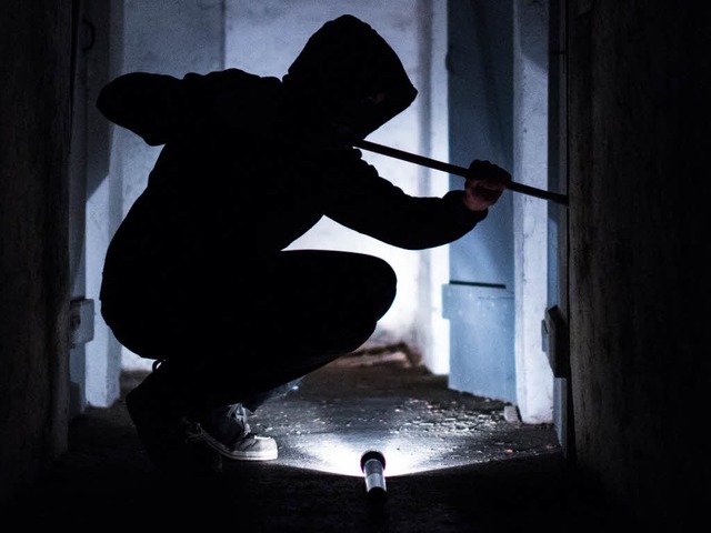 Ein fiktiver Einbrecher hebelt eine Tr auf (Symbolbild).  | Foto: dpa