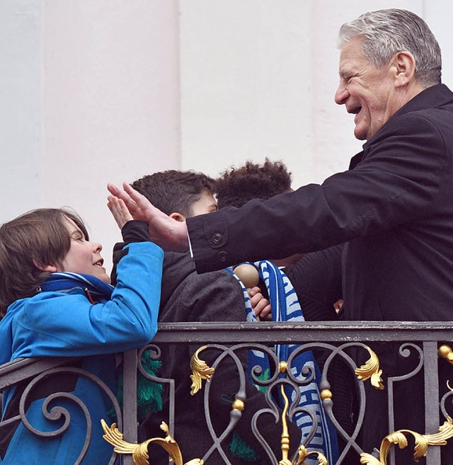 Joachim Gauck klatscht bei einem offiziellen Termin mit einem Schler ab.  | Foto: dpa