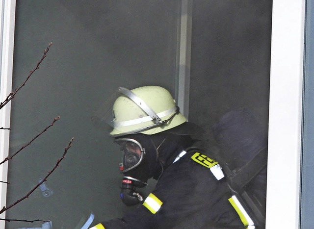 Unter Atemschutz sucht ein Feuerwehrmann Glutnester.   | Foto: Horn