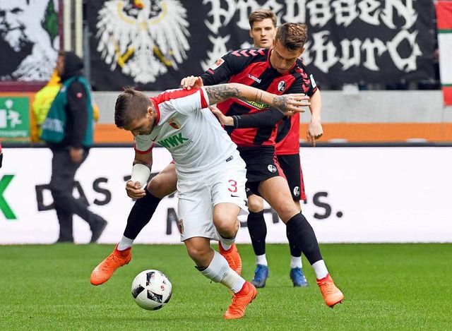 Ein zweikampfbetontes Spiel in der Arena in Augsburg.  | Foto: dpa