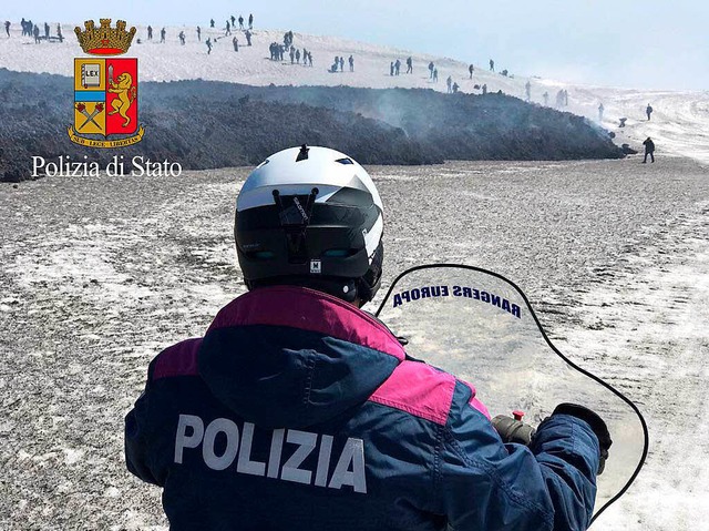 Ein Polizist kommt auf dem Schneemobil Touristen zu Hilfe.    | Foto: dpa