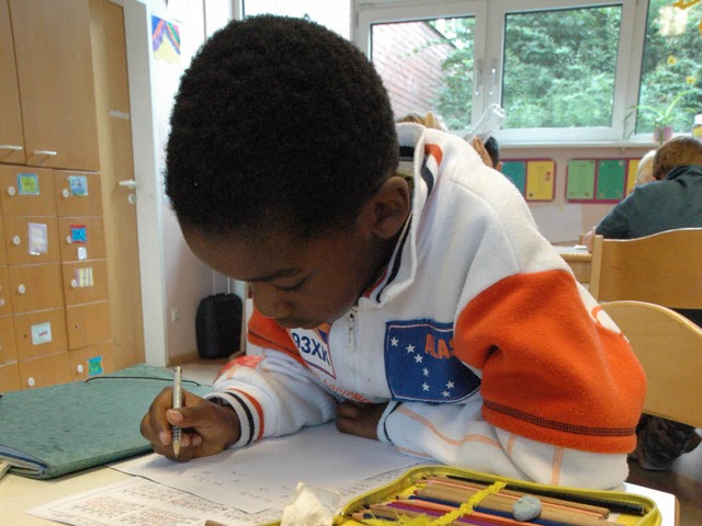 Ein Junge schreibt in einer Betreuungs...eumattschule in ein Heft (Archivbild).  | Foto: Arne Bensiek