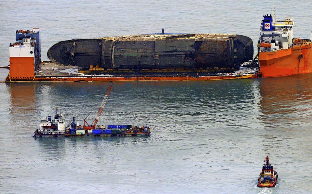 Die Sewol wird auf einem Schwerlastschiff abtransportiert.   | Foto: dpa
