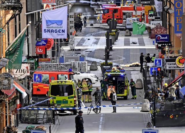 Polizisten sichern den Tatort in der Einkaufsstrae ab.   | Foto: AFP