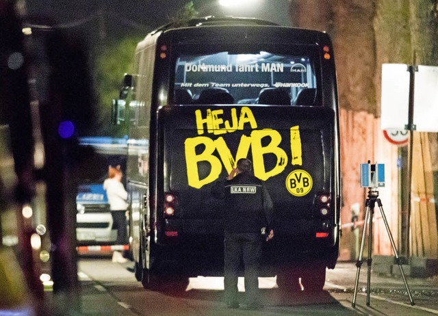 Ein Beamter des Landeskriminalamtes un...g in Dortmund den BVB-Mannschaftsbus.   | Foto: dpa