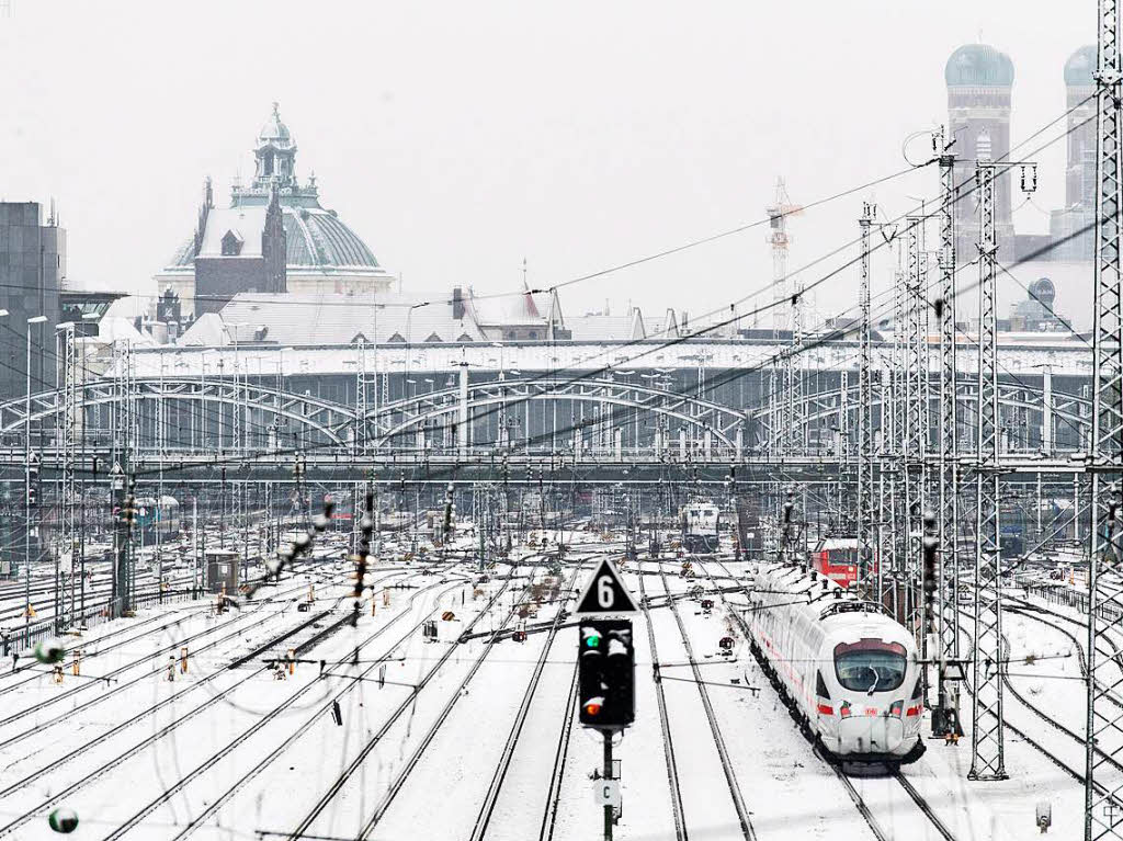 Verschneite Gleisanlagen sind am Dienstag vor dem Hauptbahnhof in Mnchen, im Hintergrund die Frauenkirche.