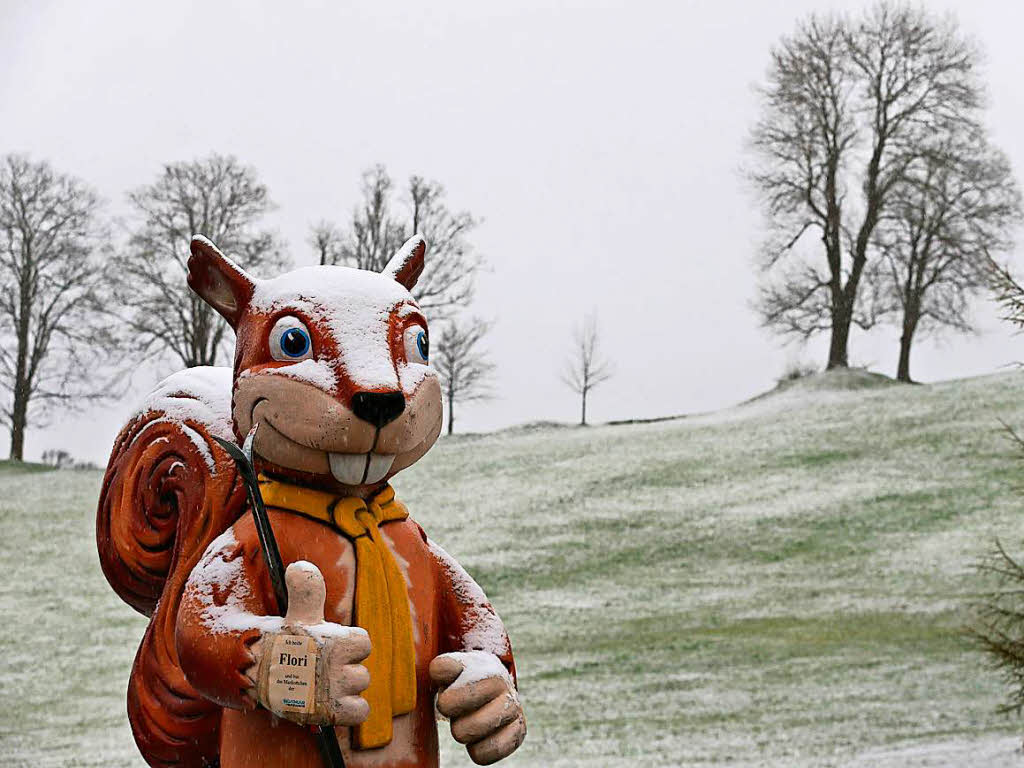 Mit Schnee bedeckt steht am Ostersonntag ein berdimensionales Eichhrnchen vor einer Skischule in Nesselwang (Bayern).