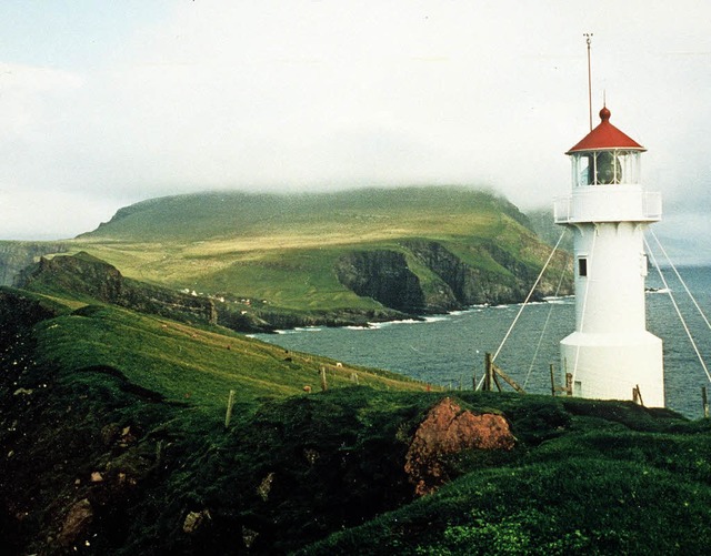 Grne Landschaft, steile Ksten und ein Leuchtturm: die Farer Inseln   | Foto: dpa