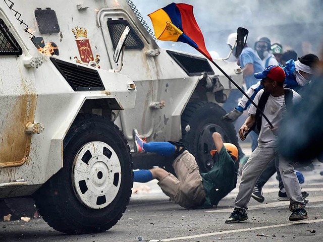 Ein Panzerwagen der Nationalgarde fhr...t in Caracas in Venezuela Menschen um.  | Foto: AFP