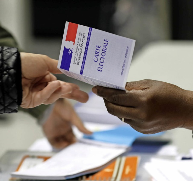Eine franzsische Whlerin zeigt am  Sonntag ihre Wahlkarte.   | Foto: dpa