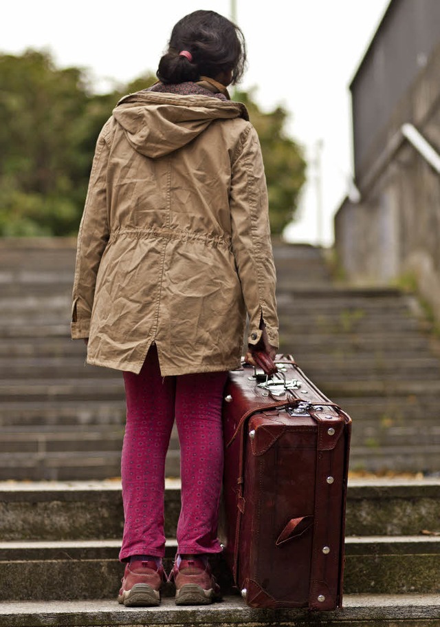 Unterwgs: Ein Flchtlingsmdchen schleppt seinen Koffer eine Treppe hinauf.   | Foto: Grochwski (Fotolia)