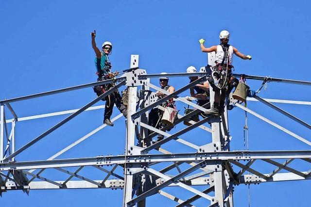 Arbeiter stellen neuen Strommasten am Wutachrand auf