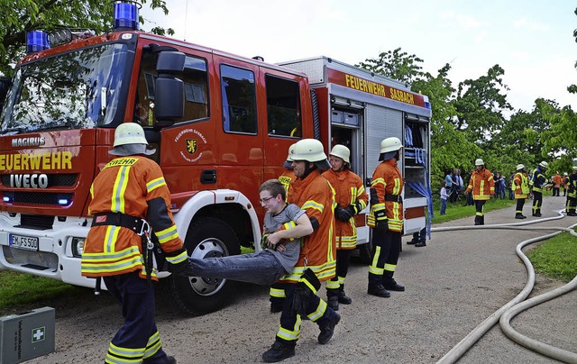 Sasbach. Feuerwehrleute die einen  ver...tragen ihn zu den Ersthelfern des DRK.  | Foto: Roland Vitt