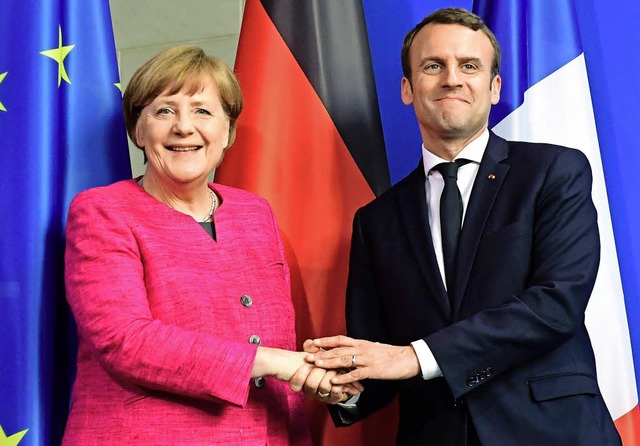 Hndedruck fr die Kamera: Emmanuel Ma...ttsbesuch bei Kanzlerin Angela Merkel   | Foto: afp