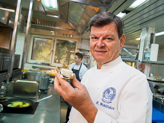 Harald Wohlfahrt mit einer Auster   | Foto: DPA