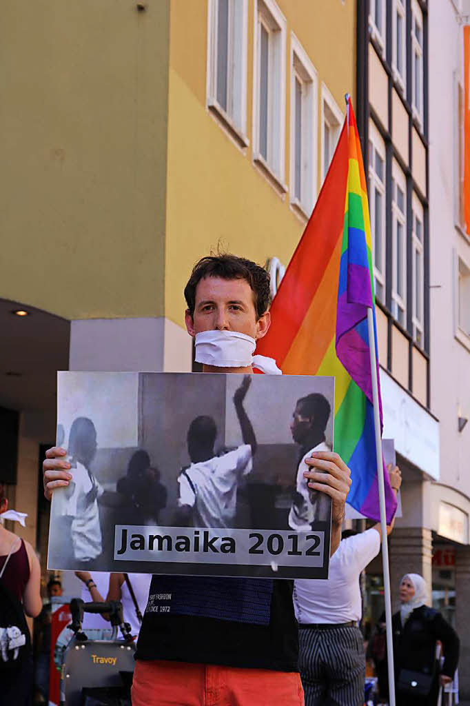 Grabkerzen und Regenbogenfarben. Mit Bildern und Schweigen machen Demonstranten auf Gewalt gegen Homosexuelle und Transgender aufmerksam.