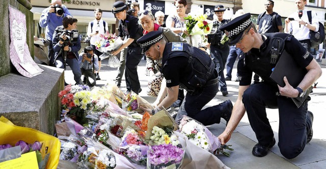 Stille Trauer: Polizisten legen am Die...nordenglischen Manchester  Blumen ab.   | Foto: dpa