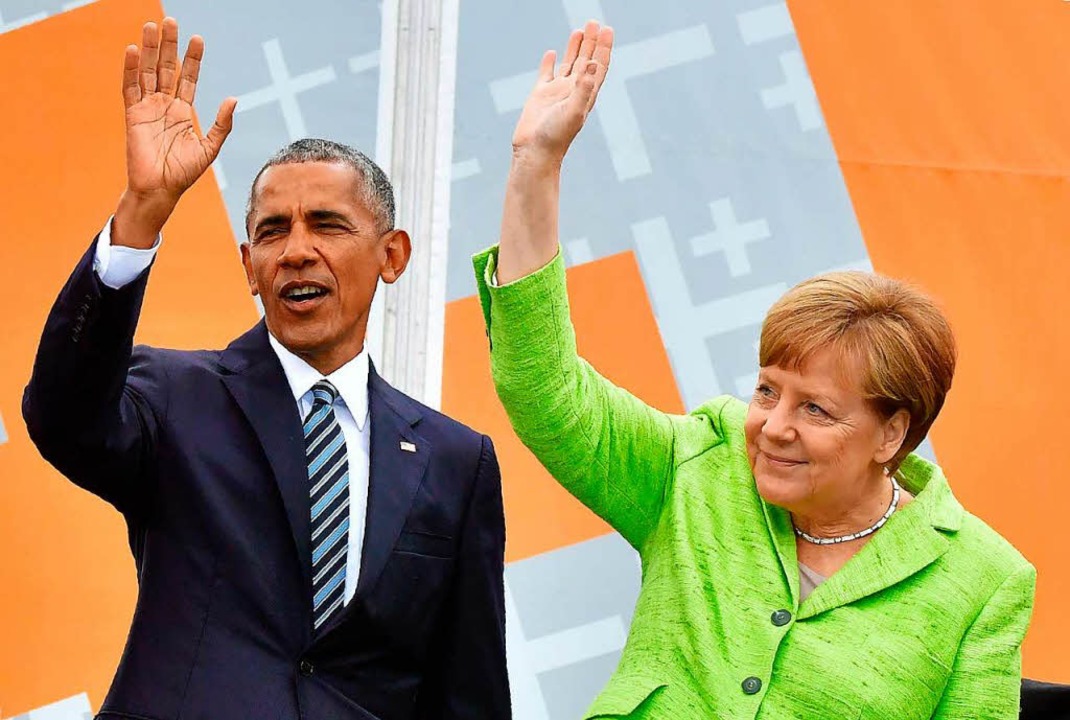 Barack Obama und Angela Merkel winken ...ngelischen Kirchentag dem Publikum zu.  | Foto: AFP