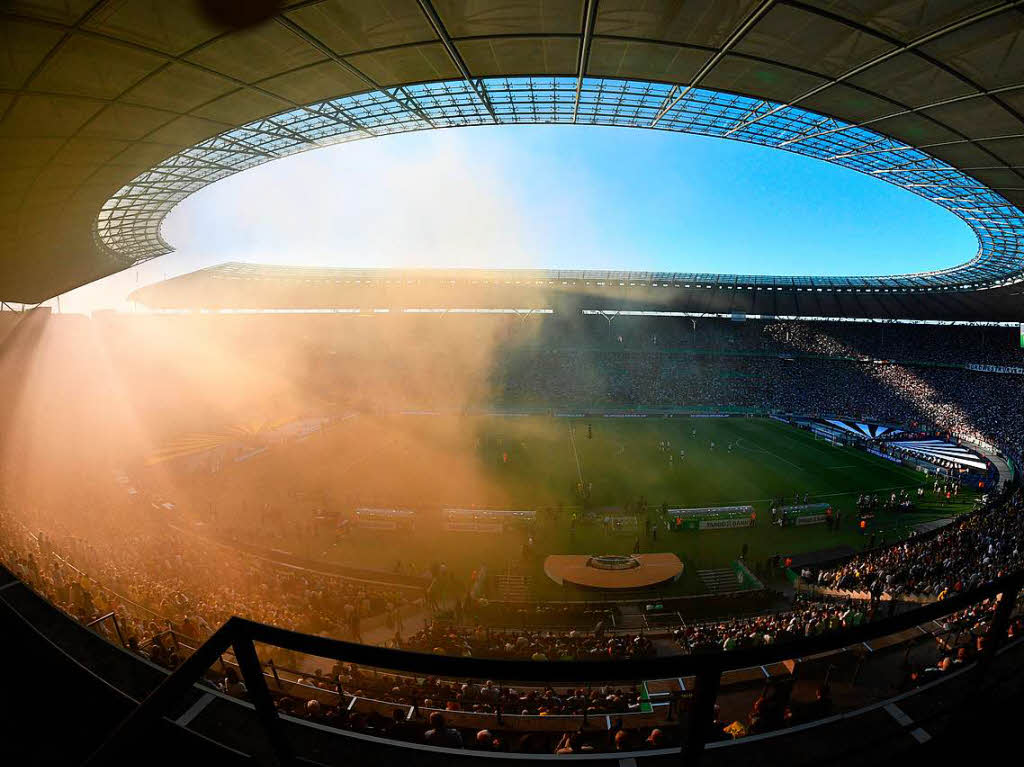 Sonnenstrahlen durchbrechen die Rauchschwaden im Olympiastadion.