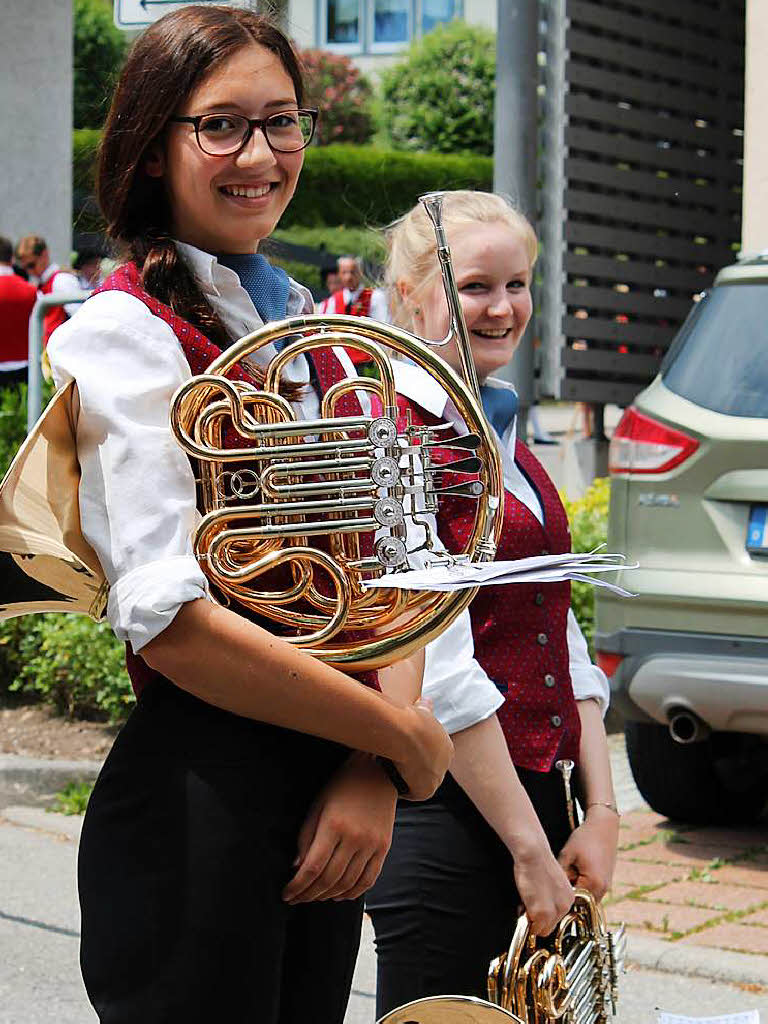 Charmante junge Musikerinnen mit Horn warten auf den Abmarsch.