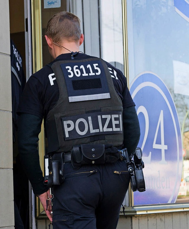 Ein Polizist bei einer Razzia gegen Pflegedienste in Berlin   | Foto: DPA