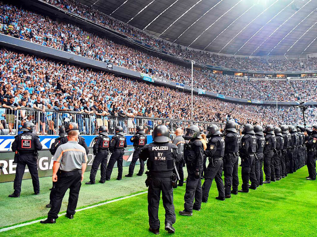 Polizisten und Ordner sichern das Spielfeld, nachdem Fans des TSV 1860 Mnchen angefangen haben zu randalieren.