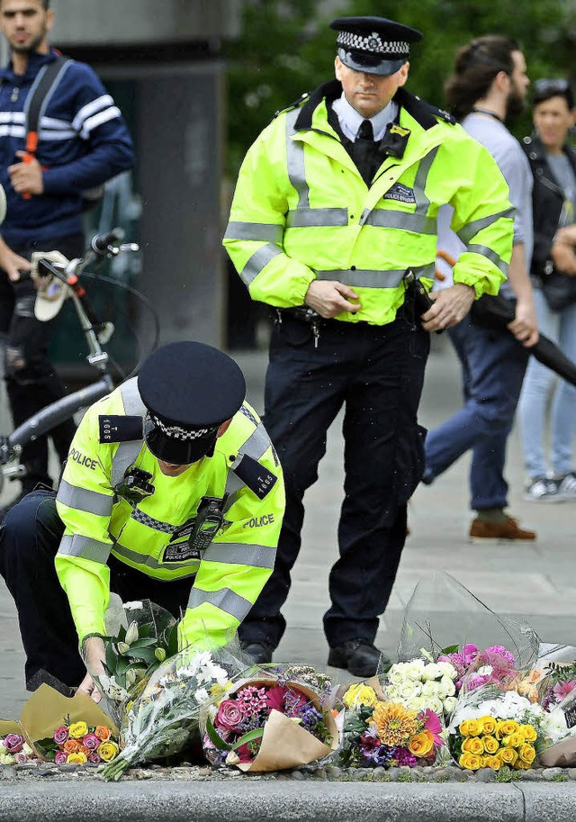 Gedenken an die Opfer:  Londoner Poliz...stag am Borough Market Blumen nieder.   | Foto: AFP