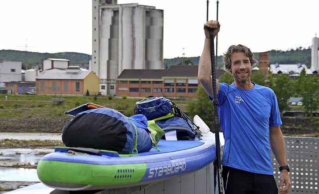 Merijn Tinga paddelt auf dem Surfboard...rch Plastikmll aufmerksam zu machen.   | Foto: Horatio Gollin