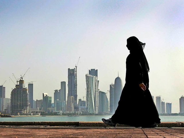 Eine Frau vor der Skyline der katarischen Hauptstadt Doha   | Foto: DPA