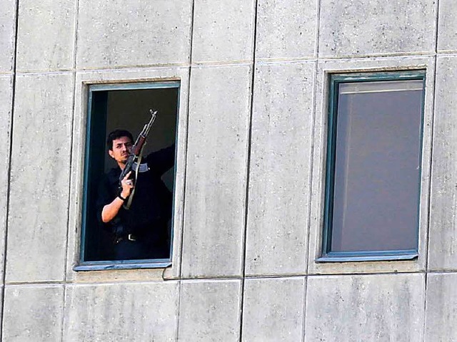 Einer der Angreifer  steht  an einem Fenster in Parlament in Teheran.   | Foto: DPA