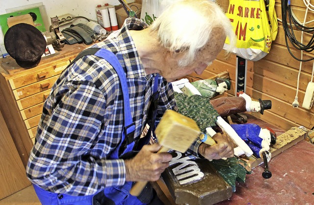 &#8222;Holzwurm&#8220; Siegfried Moll ...chnitzten Hinweisschild arg zugesetzt.  | Foto: Christa Maier