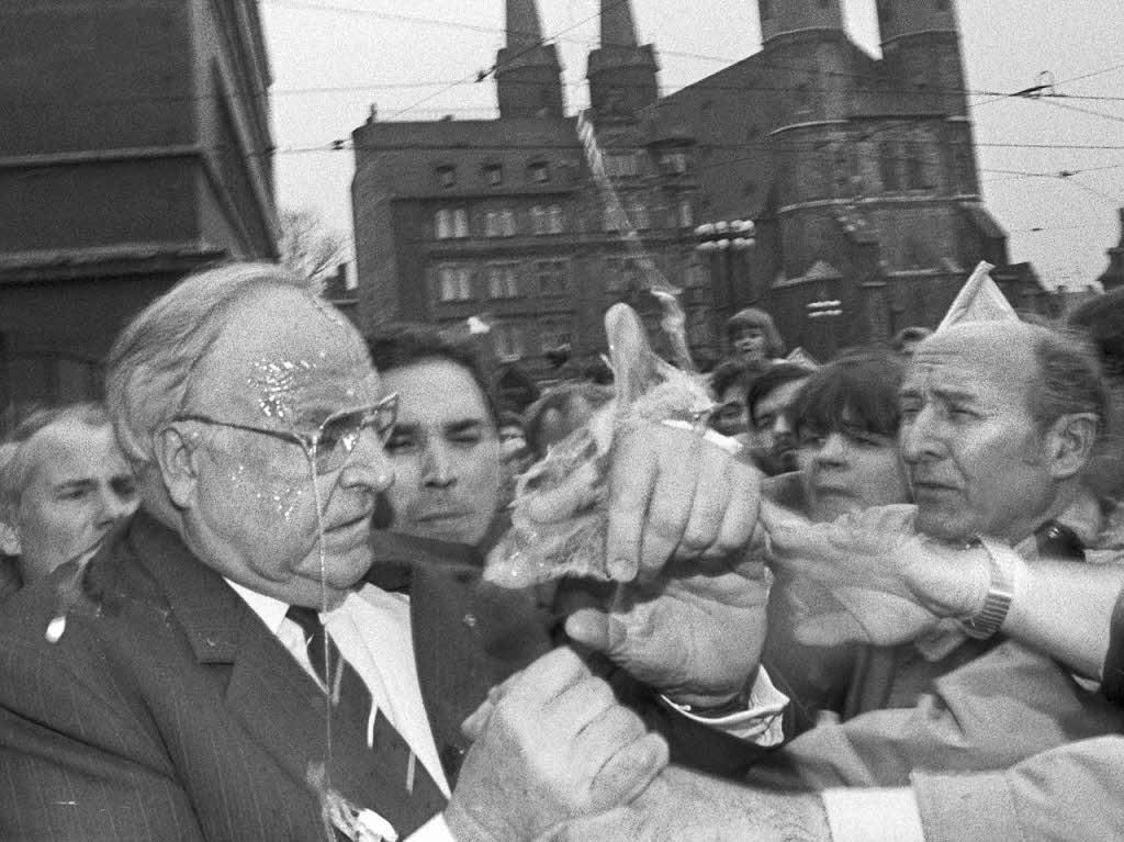 Das Eiwei tropft Bundeskanzler Helmut Kohl von der Brille, whrend er versucht, den Eierwerfer, der ihn vor demStadthaus inHalle mit einemEi beworfen hatte.