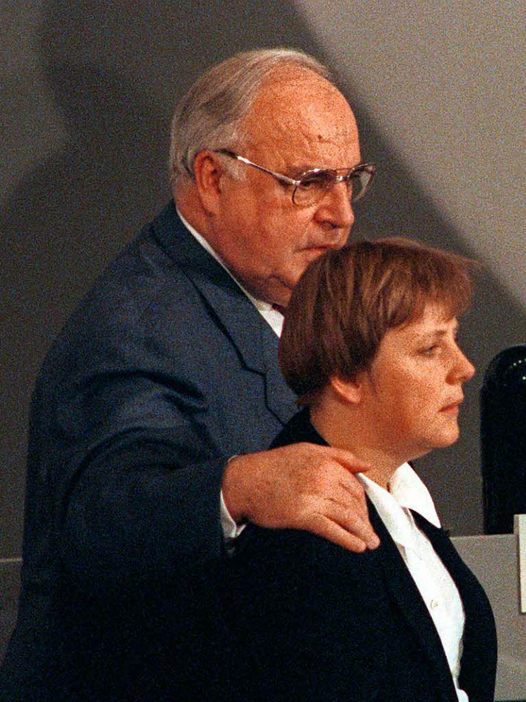 Der CDU-Vorsitzende, Bundeskanzler Helmut Kohl, legt whrend des CDU-Parteitags am 28. November 1994 in Bonn den Arm um seine Stellvertreterin Angela Merkel.