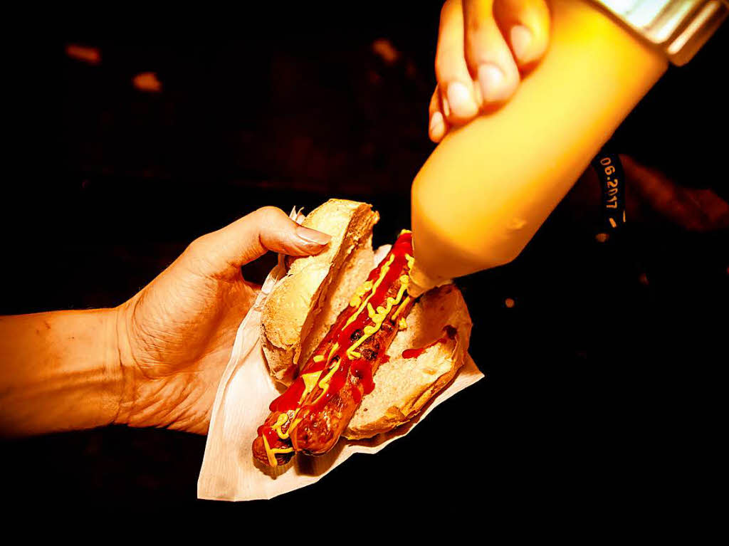 Lange Rote (geknickt) im Weckle mit Ketchup und Senf, mutmalich etwas zu lange auf dem Grill gelegen.