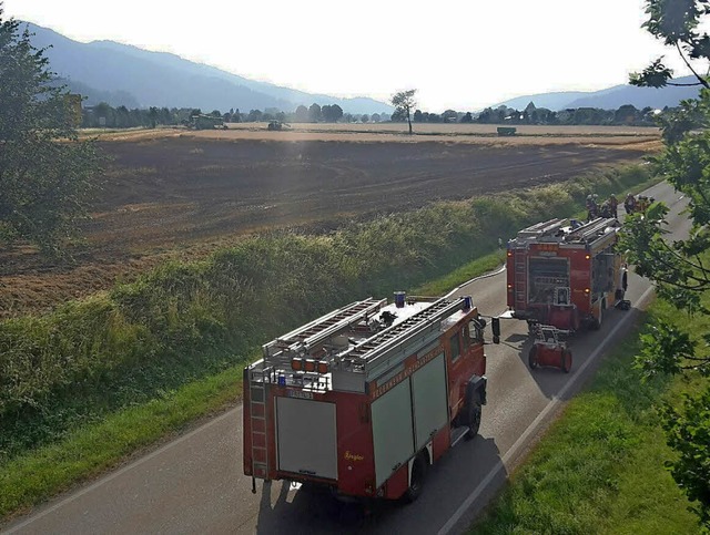 Feuerwehrfahrzeuge neben dem verkohlten Acker   | Foto: Uwe Mauch