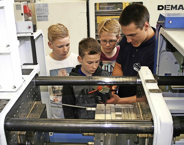 Auszubildender Steven Horn (rechts) er...ine Spritzgiemaschine funktioniert.    | Foto: IMS Gear