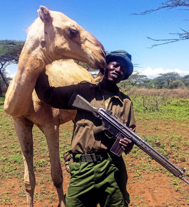 Wachmann Peter Euka mit Waffe und Kamel  | Foto: dpa