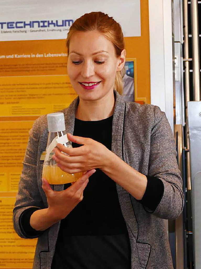 Dr. Aline Anton hlt einen Glaskolben mit Bakterienkultur in einer Nhrlsung in ihren Hnden.
