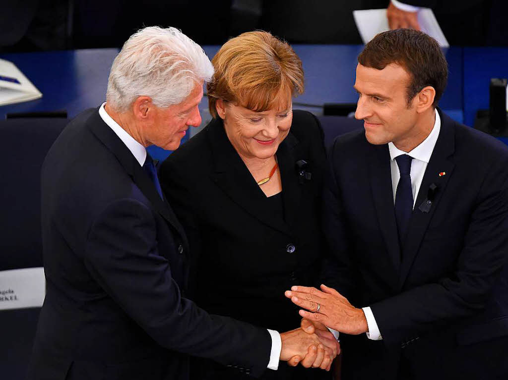Bundeskanzlerin Angela Merkel und der franzsische Prsident Emmanuel Macron (r.) zusammen mit dem ehemaligen US-Prsident Bill Clinton.