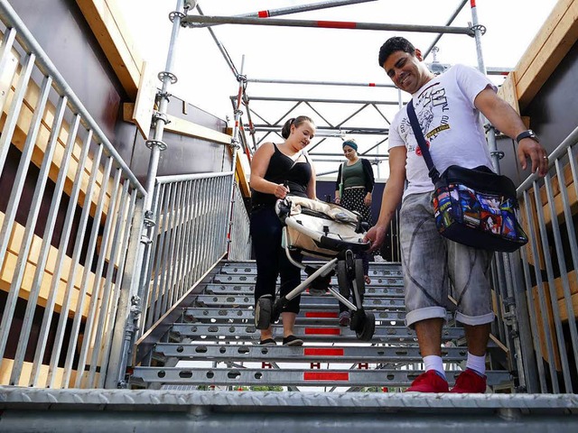 Ein Mitreisender hilft der Frau mit Kinderwagen ber die Behelfsbrcke.   | Foto: Mark Alexander