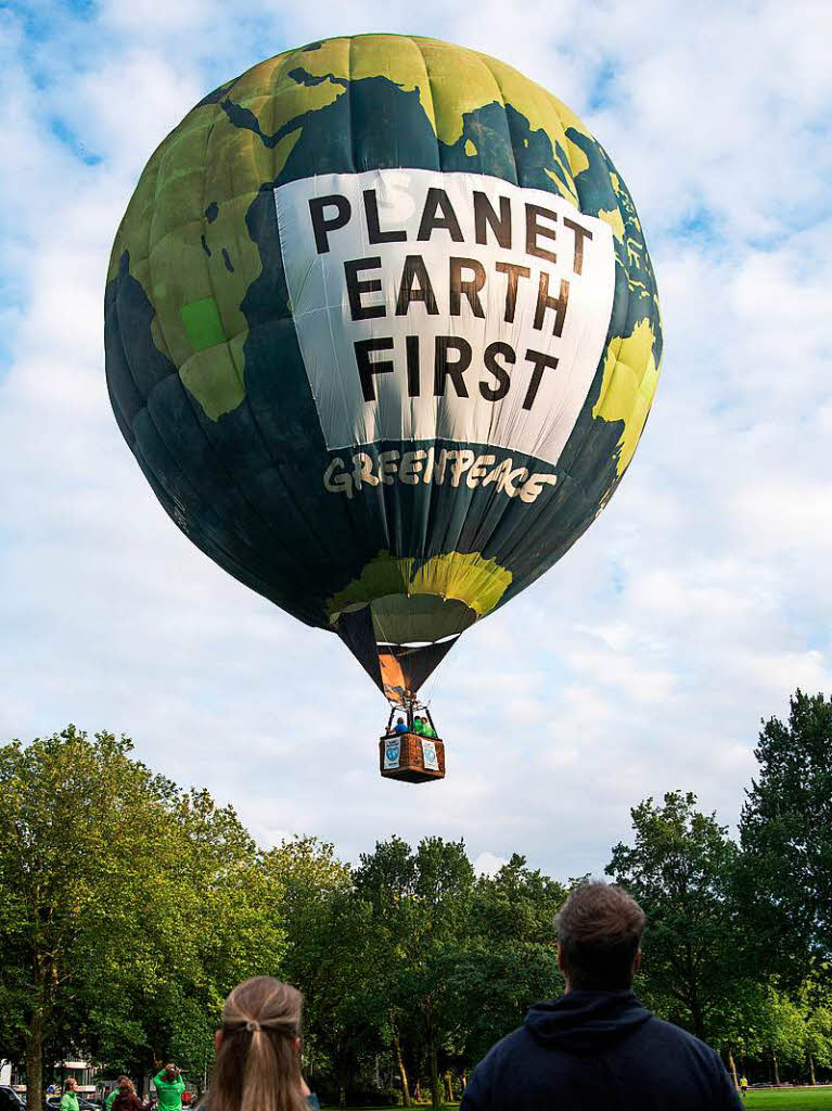 Aktivisten der Umweltschutzorganisation Greenpeace starten eine Fahrt mit einem Heiluftballon