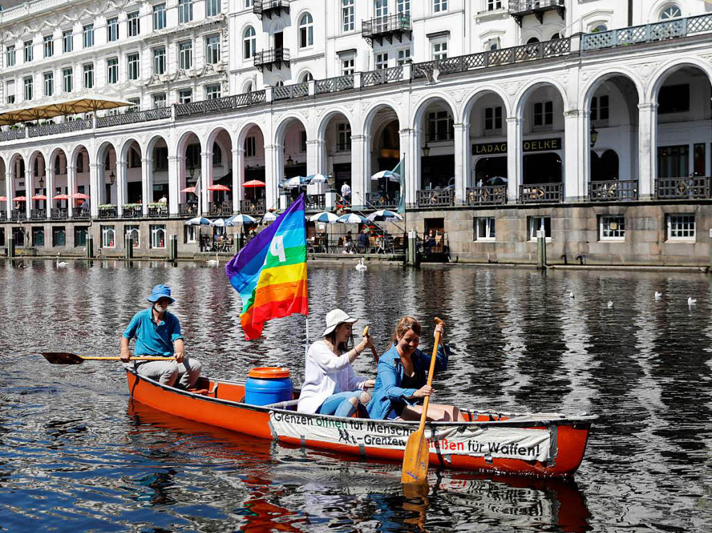 Mit einer Peacefahne paddeln Aktivisten am ber einen Alsterfleet
