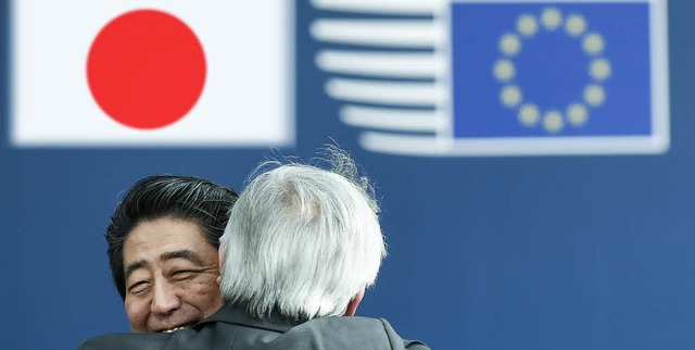 Am Tag des Kusses liegen sich der  jap...-Kommissionschef Juncker in den Armen.  | Foto: AFP/Montage: BZ
