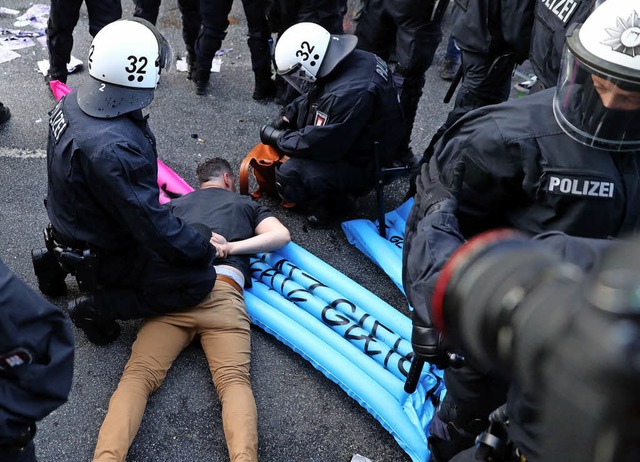 Polizisten nehmen einen Demonstranten fest.   | Foto: dpa