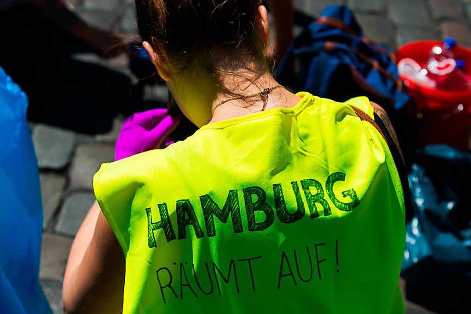 Bewohner versammeln sich am Sonntag in Hamburg vor dem Bahnhof Sternschanze, um das Schanzenviertel aufzuräumen (Foto: dpa) Bewohner versammeln sich am Sonntag in Hamburg vor dem Bahnhof Sternschanze, um das Schanzenviertel aufzuräumen (Foto: dpa)