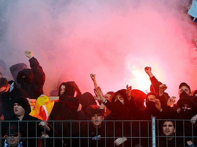 Fans des Karlsruher SC  znden am Rand...ttgart auf der Tribne Leuchtfeuer an.  | Foto: dpa